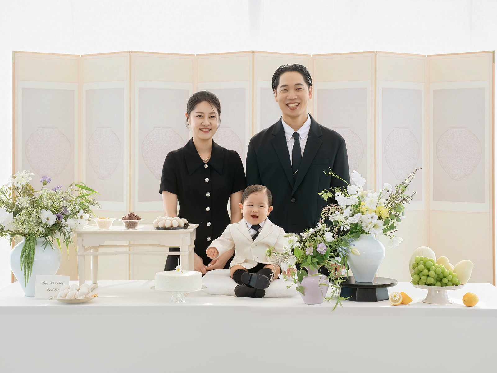 병풍과 돌상 앞에 선 부모와 아이, 돌잔치 가족사진